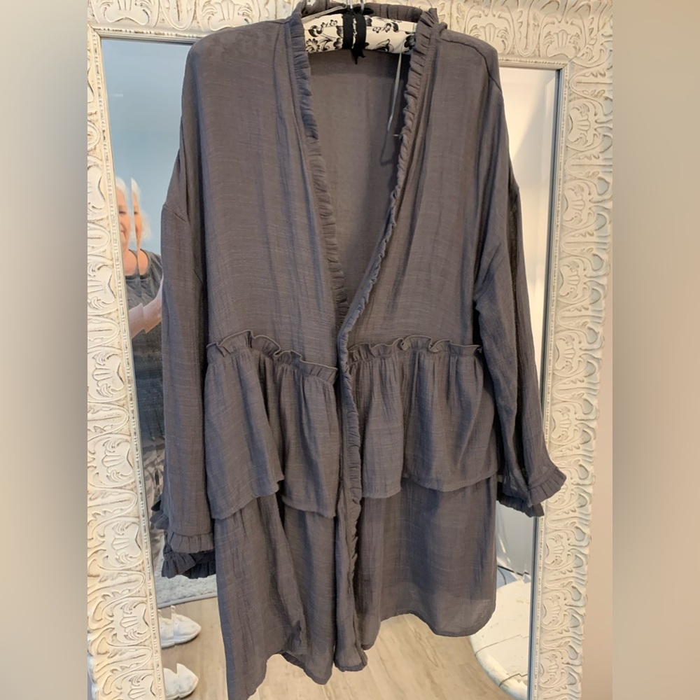 This charcoal tunic opens in front for a casual look. Dainty ruffle are cute!